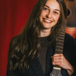 Camille, professeure de chant, avec sa guitare